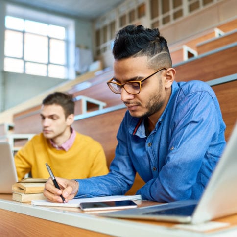 Two students sitting at desks in modern auditorium